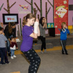 Grupo de niños y adultos haciendo yoga