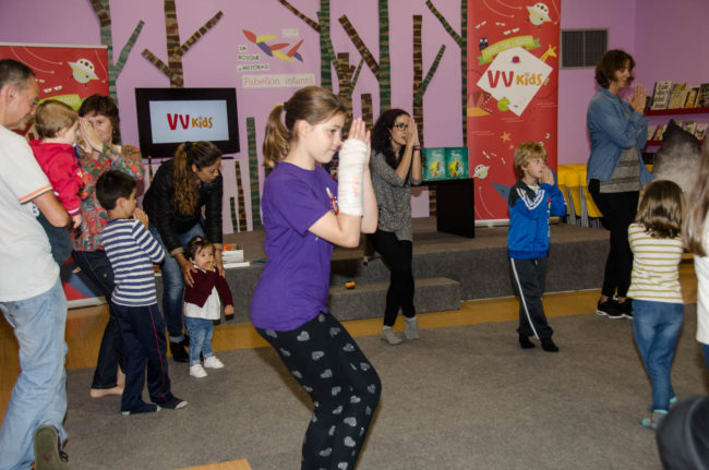Grupo de niños y adultos haciendo yoga